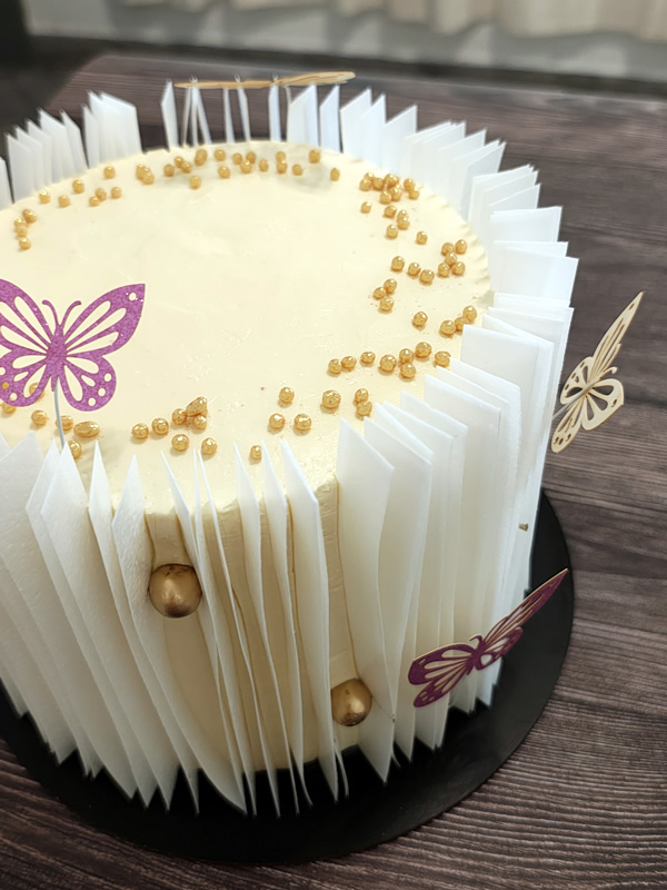 Torta de celebración con detalles en papel de arroz y mariposas